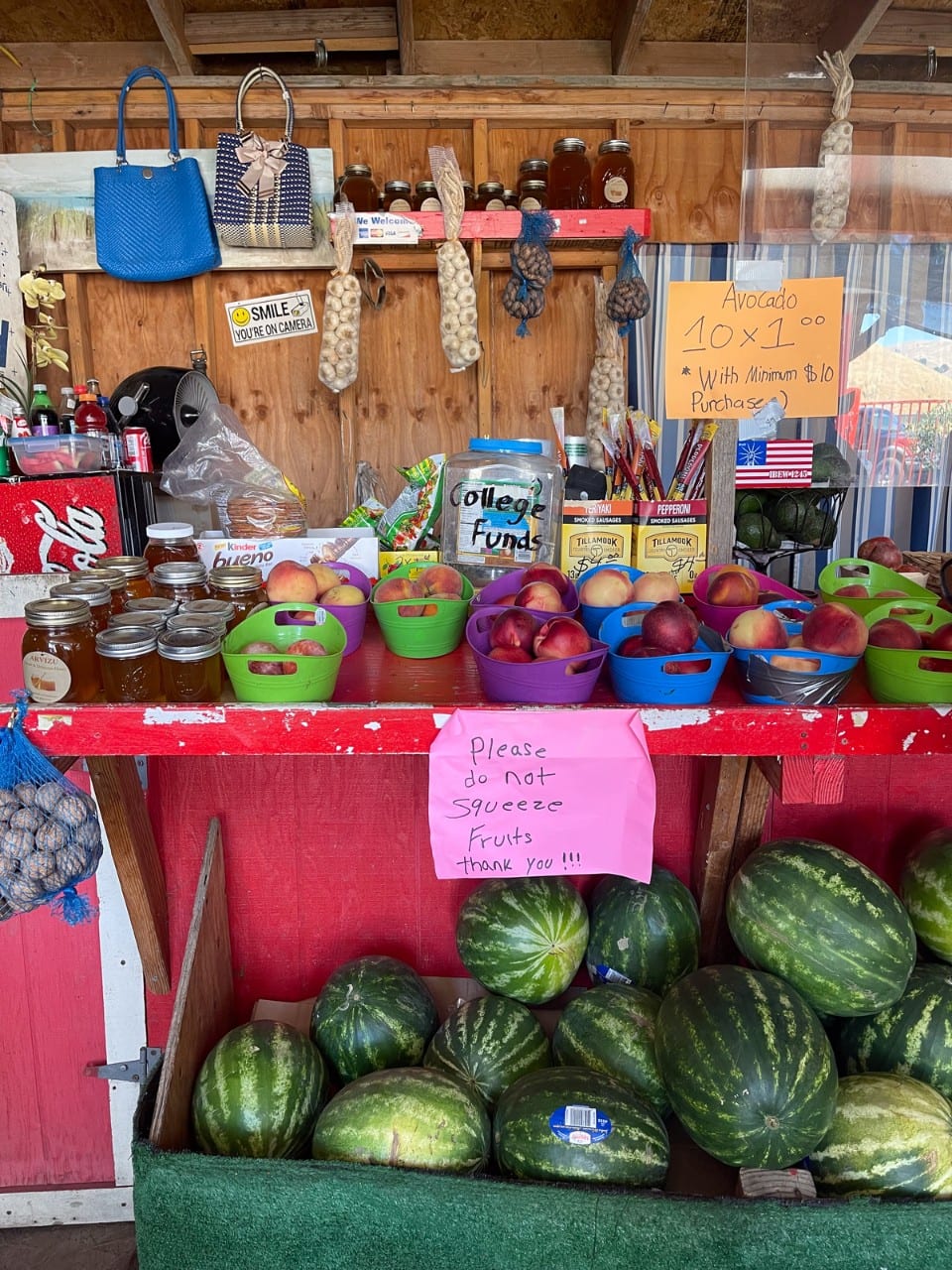 A colorful array of fruits and nuts with other small snack items for sale sit in a roadside booth.